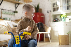 smiley kid with tricycle indoors