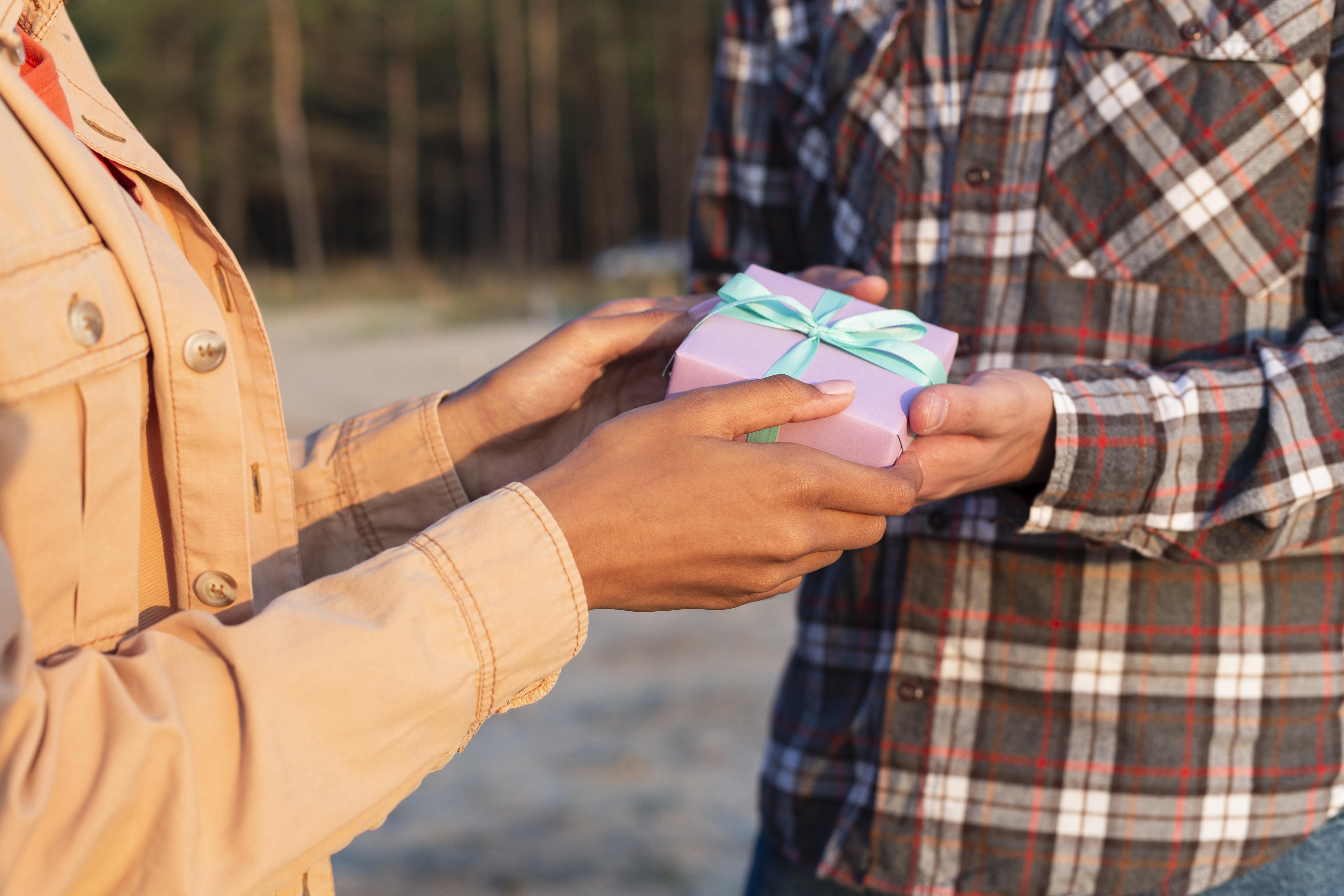 side view man giving his girlfriend wrapped gift 1
